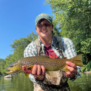Angler holding a big brown trout in the river