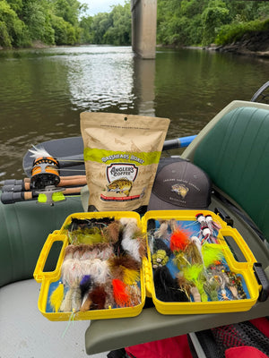 Bassheads coffee and fly boxes in a green boat on the river