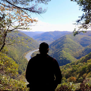 Angler looking out over a river gorge from a fall overlook
